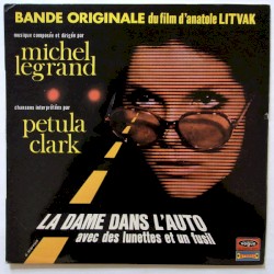 La dame dans l'auto avec des lunettes et un fusil